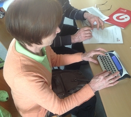 Foto: Frau bedient einen Lightwriter, ein Kommunikationshilfsmittel, das Geschriebenes spricht.