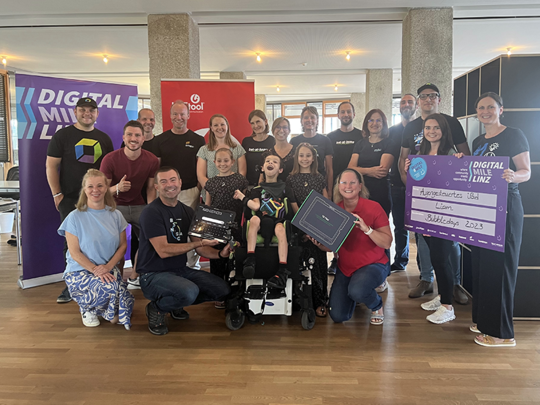 Gruppenfoto: Übergabe eines augengesteuerten iPads an Liam