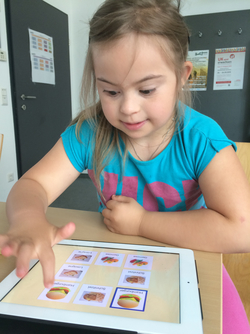 Foto: kleines Mädchen mit Beeinträchtigung sitzt vor dem iPad